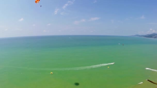 Fallschirmjäger fliegt in der Nähe der Stadt über dem Meer — Stockvideo