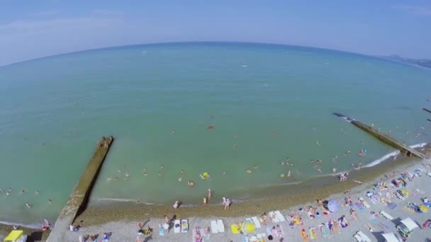 Muitas pessoas descansam na praia — Vídeo de Stock