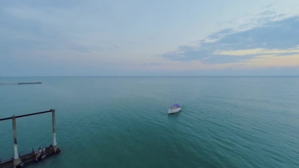 Маленькая яхта отплывает к причалу — стоковое видео