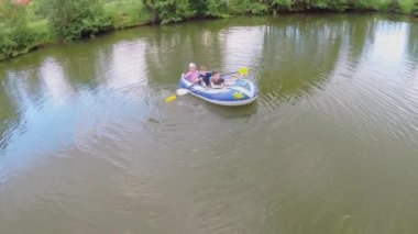 Gölet tarafından şişirilmiş teknede üç çocuk