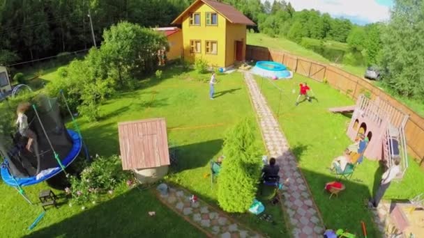 Sechs Personen spielen Badminton auf Hof — Stockvideo