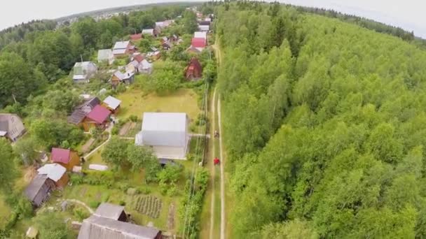 Mensen rijden op de quads over de weg in huisje dorp op zomer — Stockvideo