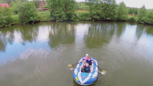 Трое детей плывут на надутой лодке — стоковое видео