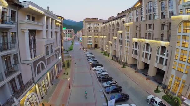 Улица с людьми и припаркованными машинами в отеле — стоковое видео