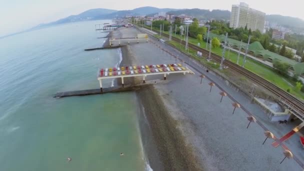 Spoorweg in kuststad vlakbij kiezelstrand — Stockvideo