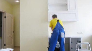 İşçiler raflar asmak için kapı montajı.