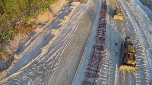Рабочие прогулки возле железной дороги и бульдозеров — стоковое видео
