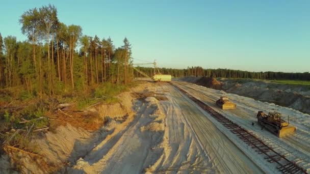 Бульдозери стоять біля залізниці на пісочниці — стокове відео