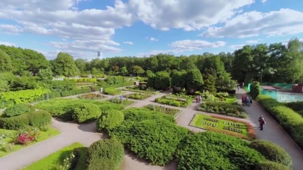 Menschen spazieren durch Gassen im Rosarium — Stockvideo