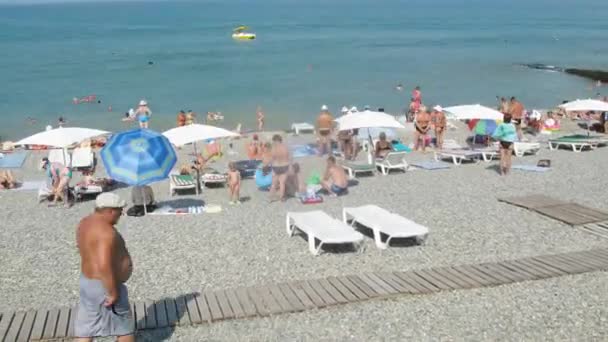 Menschen entspannen sich am Strand — Stockvideo