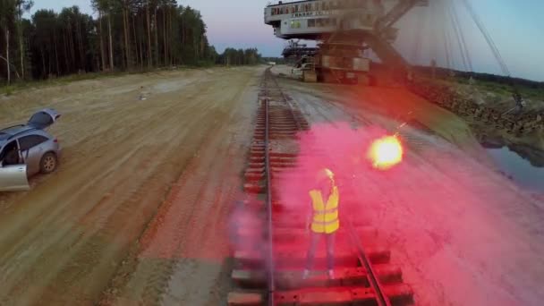 Mujer con casco y soportes uniformes en el ferrocarril — Vídeo de stock