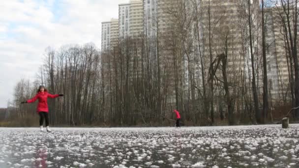 Три человека катаются на коньках по замерзшему пруду — стоковое видео