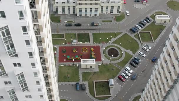 Детская площадка среди современных зданий — стоковое видео