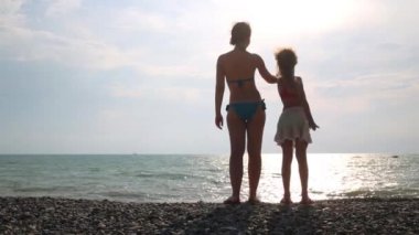 Anne ve kızı el ele tutuşuyorlar.