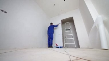 Adam düzgünleştirir fiberglas odasında bir spatula ile