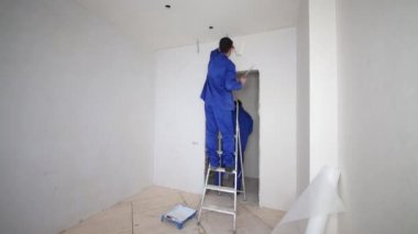 Bir merdiven düzgünleştirir fiberglas bir silindir ve spatula kullanarak üzerinde çalışan