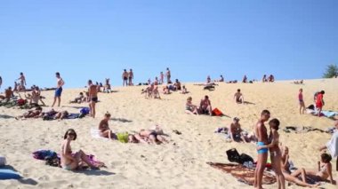 Kumsalda güneşlenirken insan kalabalığı