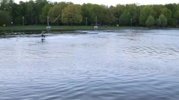 Wakeboarder διαφάνειες επί του σκάφους σε λίμνη — Αρχείο Βίντεο