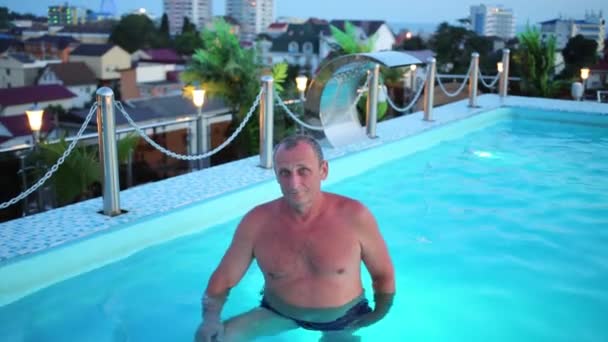 Homme âgé plonge dans la piscine bleue — Video