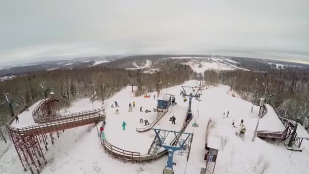 Several chairlifts on snow slope with people — Stock Video