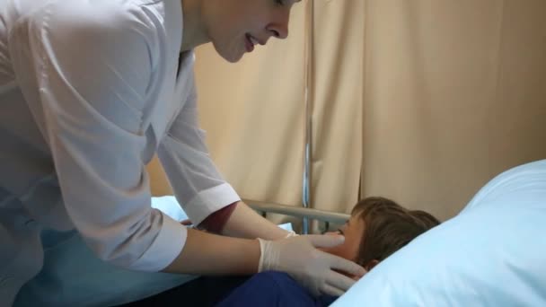 Kvinnliga läkare undersöker pojke — Stockvideo