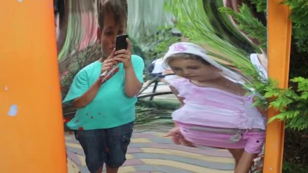 Dívka a chlapec stojící poblíž falešné zrcadlo — Stock video
