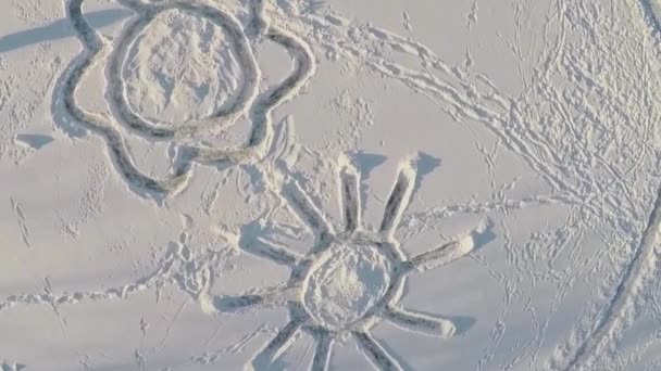 Цветок и солнце, созданные на снегу — стоковое видео