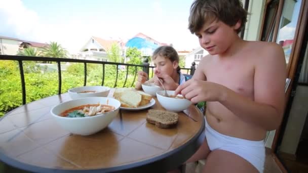 Boy and girl eats on balcony — Stock Video