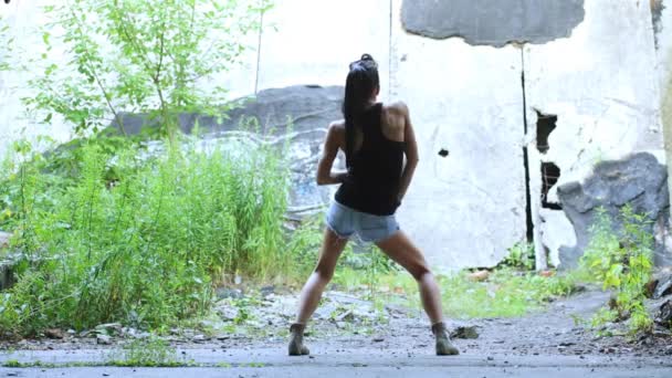 Chica bailando contra pared cubierta — Vídeo de stock