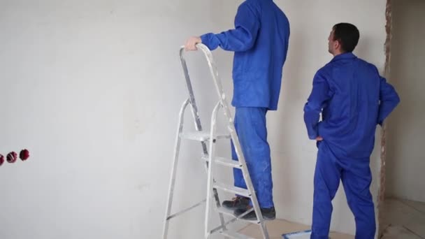 Zwei Arbeiter reparieren einen Raum — Stockvideo