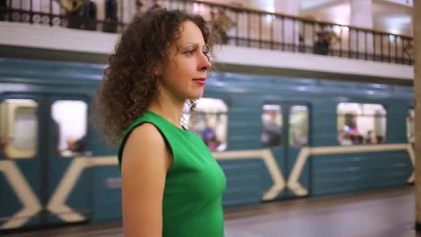 Femme en robe se tient à la station de métro — Video