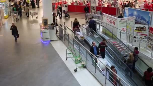 La gente sube y baja en escaleras mecánicas — Vídeos de Stock