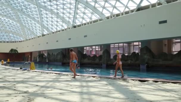 Menino e menina vão perto da piscina — Vídeo de Stock