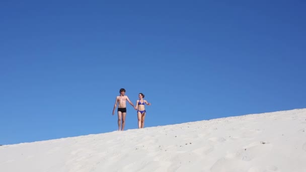 Man en vrouw lopen op strand — Stockvideo