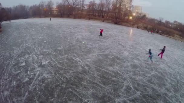Children skating and play on icy pond — Stock Video