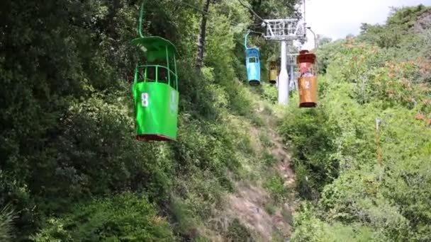 Vagones abiertos funiculares se mueven a través de los árboles — Vídeo de stock