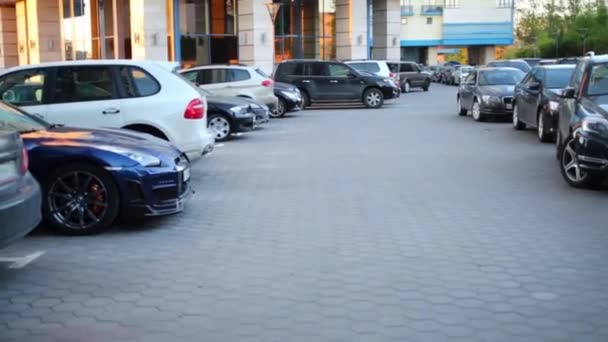 Samochody na parkingu w pobliżu budynku mieszkalnego na lato — Wideo stockowe