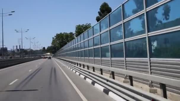 Автомобили на современной дороге с прозрачной стеной — стоковое видео