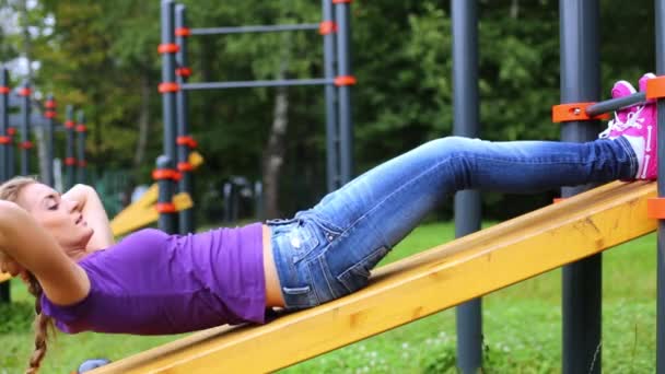 Young girl doing abdominal crunches — Stock Video