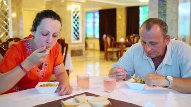 Mujer y anciano se sienta a la mesa — Vídeo de stock