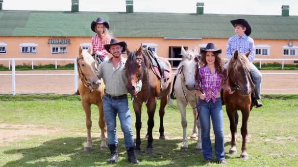 Família com cavalos contra edifício de agachamento — Vídeo de Stock