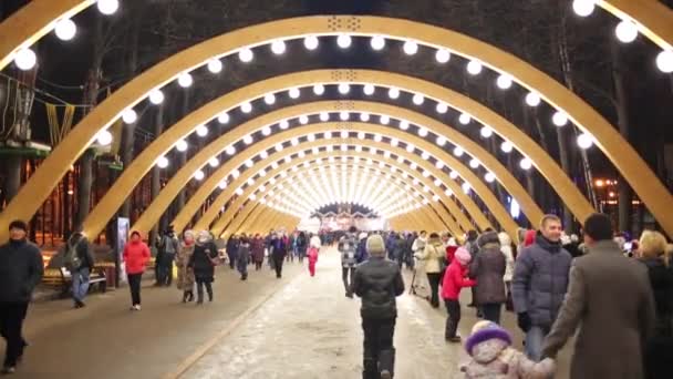 Mensen lopen op verlichte gebogen alley — Stockvideo