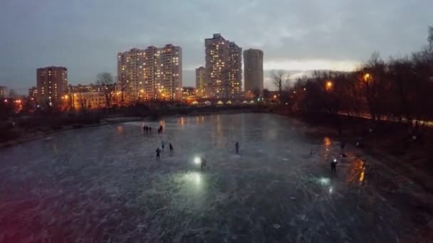 Дети катаются на коньках на ледяном пруду — стоковое видео