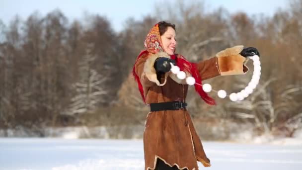 Woman dances holding stretched garland — Stock Video