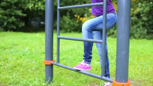 Ung flicka klättrar upp gym stege — Stockvideo