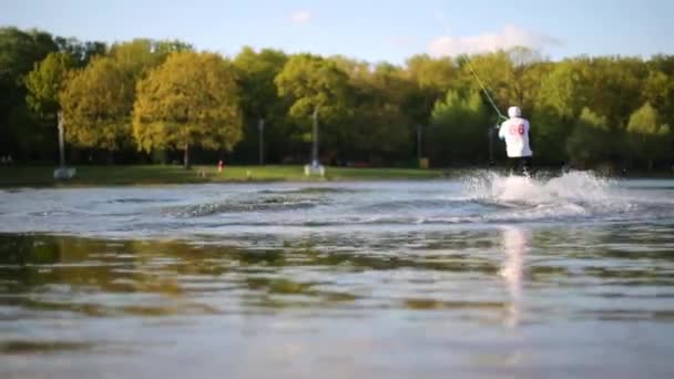 Male wakeboarder rides on board at pond — Stock Video
