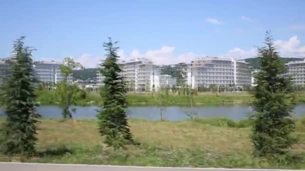 Невелике містечко з білими будівлями біля річки — стокове відео