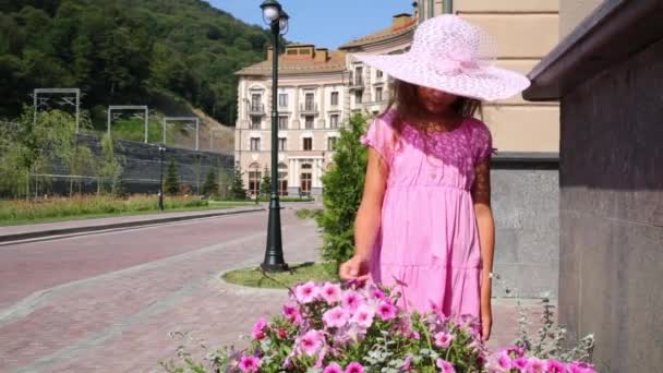 Hübsches Mädchen schnuppert rosa Blumen — Stockvideo