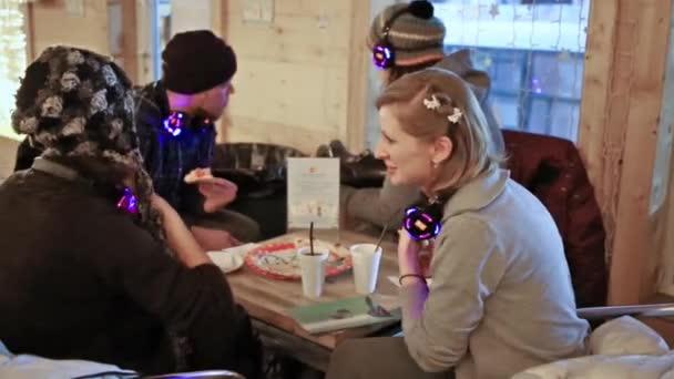 Les gens assis dans un café avec une patinoire — Video