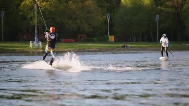 Wakeboarders entrenan a bordo en el estanque Putyaevsky — Vídeo de stock
